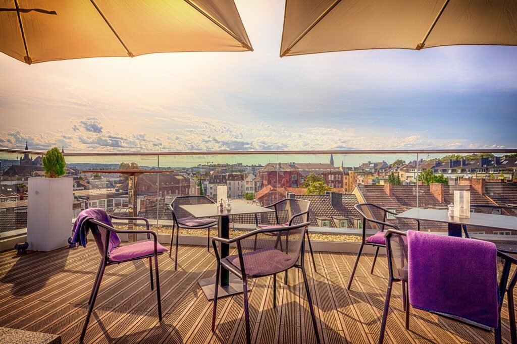 Sillas y mesas ce plástico en una terraza con vista a la costa