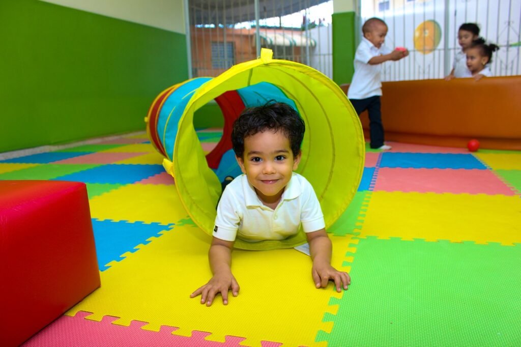 Niño en tobogan dentro de una área de juegos infantil