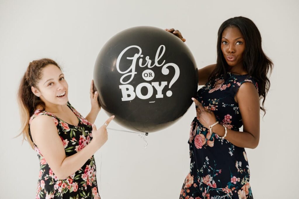 Mujeres sujetando un globo negro que dice girl or boy